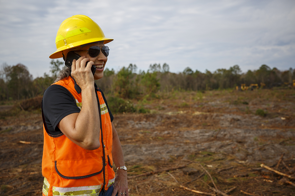 Terri Hall in safety vest talking on phone