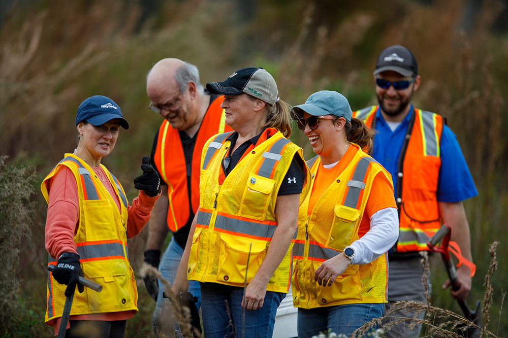 A group of employees laughing together at the planting event