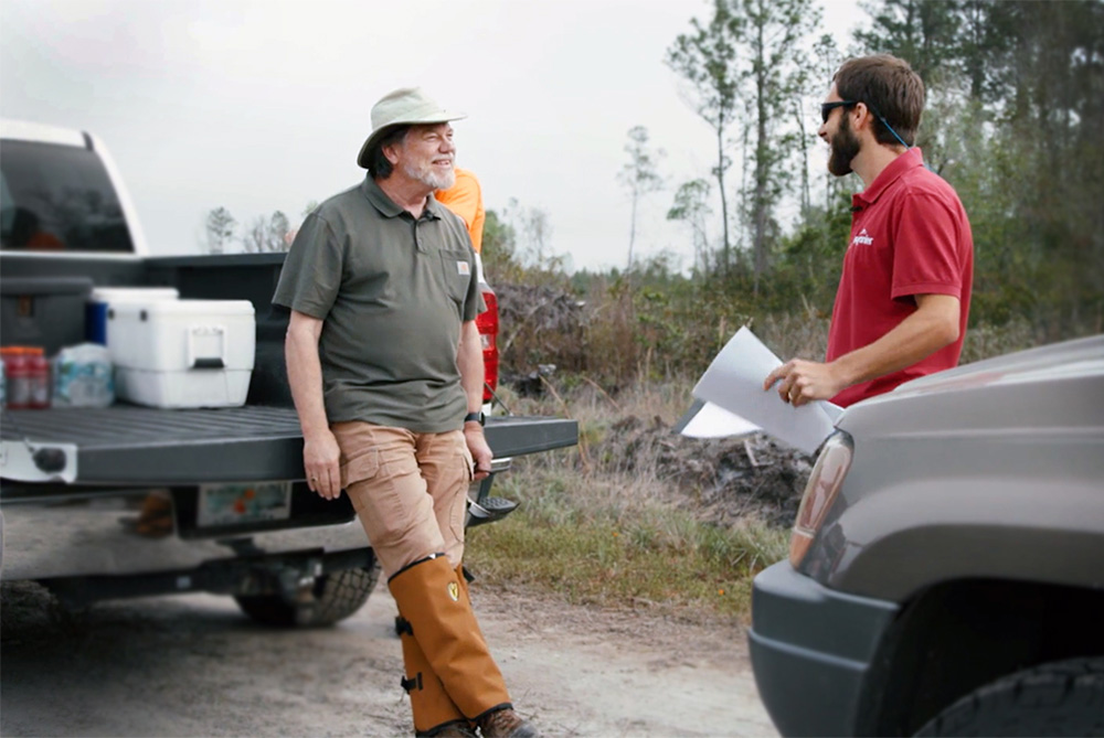 SFI auditor Richard Boitnott leaning on a truck and talking to New England Forestry Forester