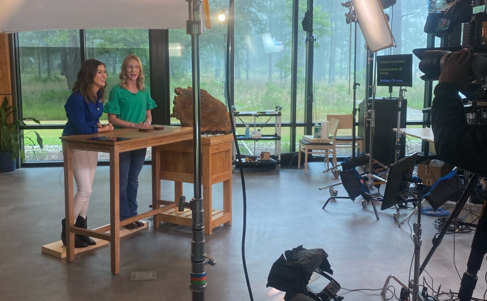Shawn and Georgia Public Broadcasting host stand at a table on on a TV set.